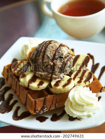 close up chocolate waffle and banana with sweet sauce