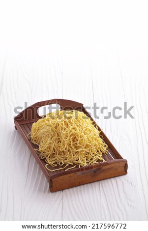 chinese dry noodle in wooden dish on white background