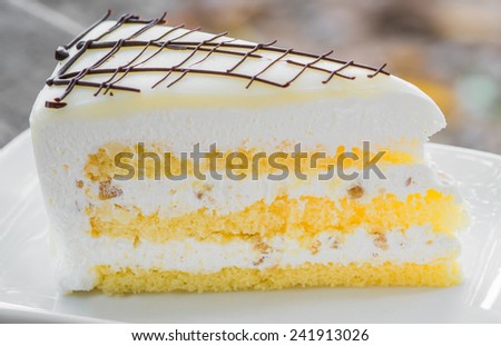 close up of a white chocolate cream cake on white plate