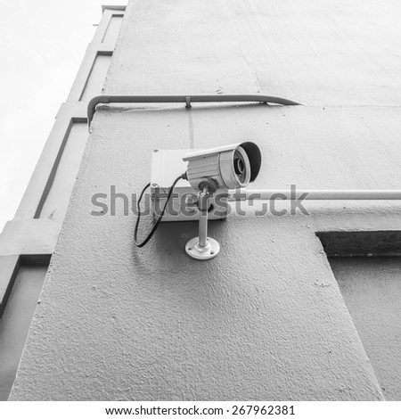 cctv camera install the wall outside building with black and white color tone