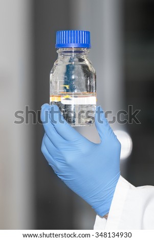 at the laboratory  - holding a reagent bottle in the hand