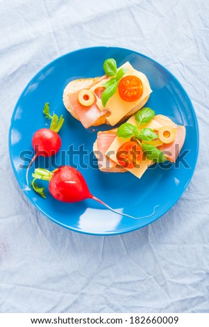 small sandwiches with smoked ham, cheese and cherry tomato