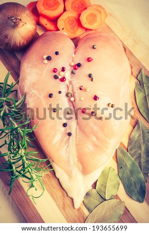 vintage photo of raw chicken breast on cutting board