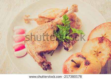 vintage photo of Roasted duck leg with apples