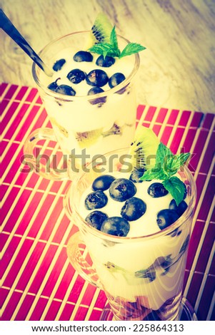 vintage photo of Fresh fruit in cream. A dessert from fruit and cream