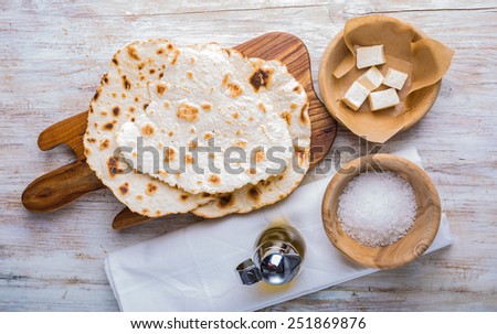 Fried tortilla with cheese on olive wood plate on white background