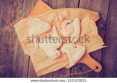 Vintage photo of raw chicken wings on wooden table