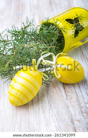 Easter decoration - yellow eggs and juniper on a wood table