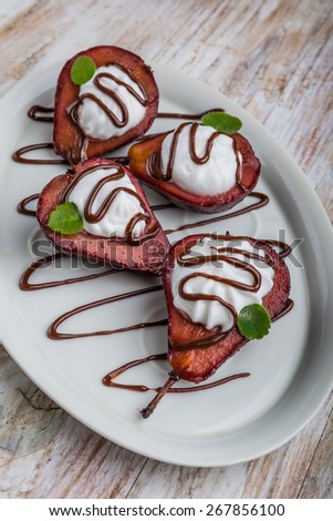 Pears cooked in red wine dipped in whipped cream and chocolate
