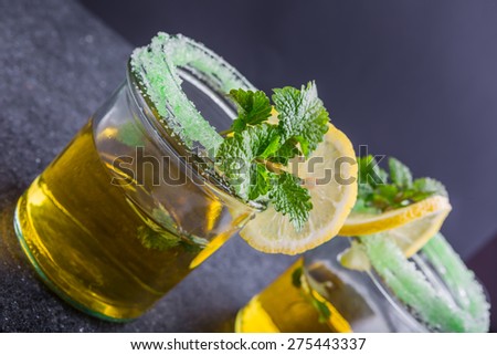 Herbal Tea with a fresh lemon balm leaves on a black table