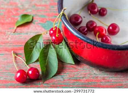 Fresh cherries in pot on old wooden table. studio shot