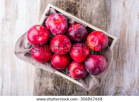 Many ripe plums on old wooden table. studio shot