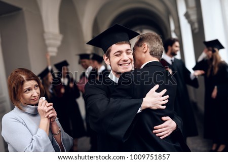 Parents congratulate the student, who finish their studies at the university. He graduates. They are very happy about this.
