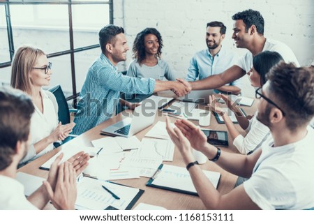 Successful Business Team Congratulating Colleague. Group of Young Happy Collegues Celebrating in Modern Office. Creative Successful Team at Work. Teamwork Concept. Corporate Lifestyle
