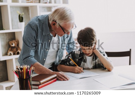 Grandson Doing School Homework with Old Man Home. Family Relationship Between Grandfather and Grandson. Grandpa Teaching, Male Grandchild, Learning Concept. Relations and People Concept.