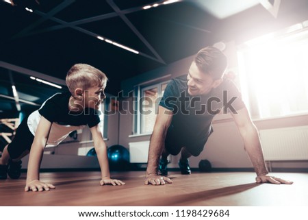 Father And Son Are Doing Push Ups In The Gym. Parenthood Relationship. Sporty Family Concept. Active Lifestyle. Triceps Exercise. Holiday Leisure. Working Out Together. Fitness Day.
