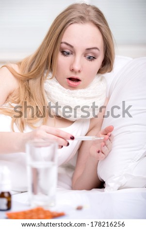 Woman with thermometer sick colds, flu, fever and migraine in bed