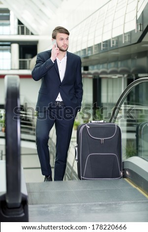 Young businessman with a suitcase and plane tickets at the airport to travel trips