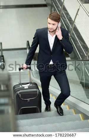 Young businessman with a suitcase and plane tickets at the airport to travel trips