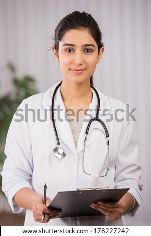 Indian doctor wearing a white coat with stethoscope