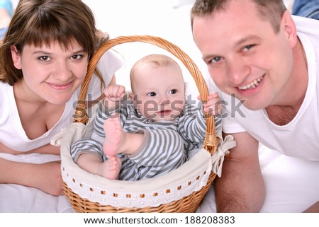 Parents play with newborn baby at home. Happy family.