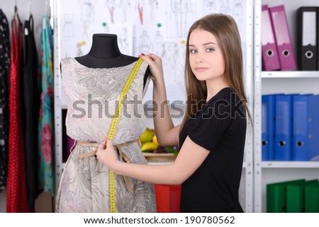 Fashion designer at work. Beautiful young woman working in fashion design studio