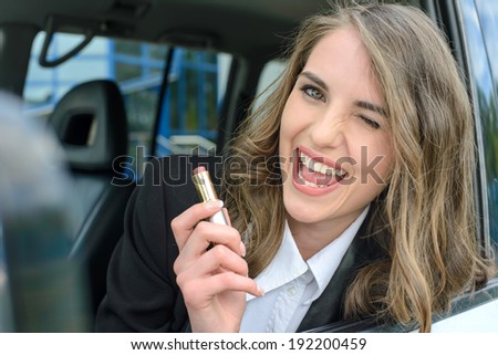Pretty young woman in a car doing makeup.