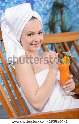 Spa & Wellness. Closeup of pretty smiling woman with juice by the pool