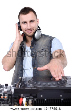 Cool DJ at work. Happy young men spinning on turntable while isolated on white