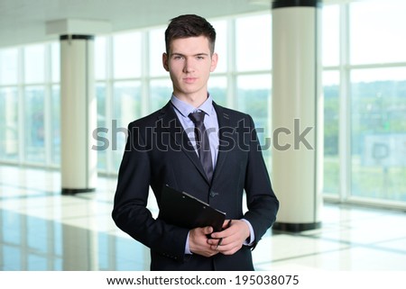 Portrait of a smiling handsome businessman in a business center