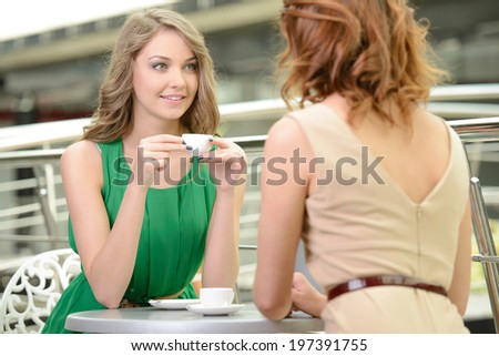 Relaxing after shopping. Two beautiful young women drinking coffee at the restaurant