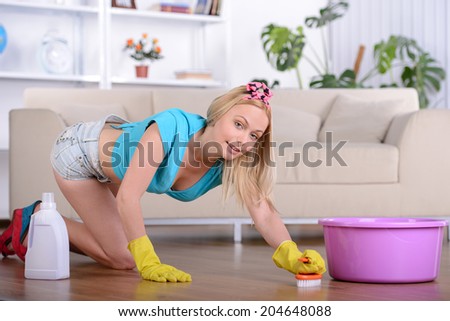 Beautiful housewife cleans the floor at home