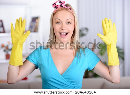 Beautiful housewife in gloves for cleaning in the home