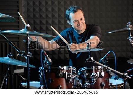 Young man behind drum-type installation in a professional recording studio