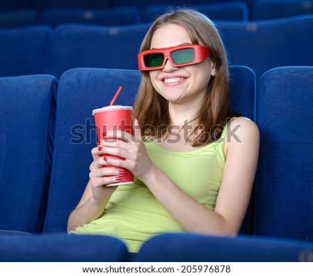 Women at the cinema. Beautiful young women drinking soda while watching movie at the cinema