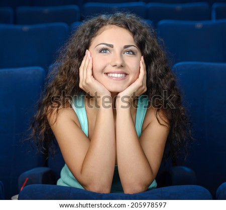 Watching romantic movie. Thoughtful young women watching movie at the cinema