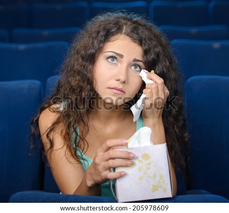 Watching romantic movie. Thoughtful young women watching movie at the cinema