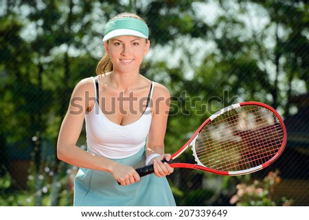 A young woman tennis player during a game of tennis on the tennis court