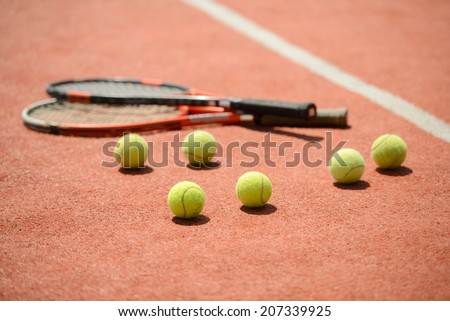 View of tennis racket and balls on the clay tennis court