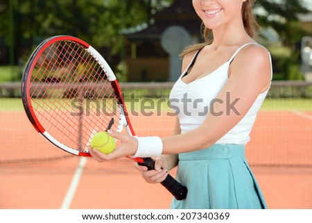 A young woman tennis player during a game of tennis on the tennis court