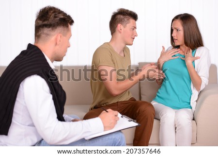 Young couple talking with family psychologist to solve their problems