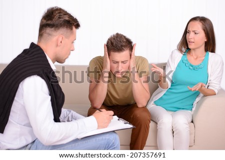 Young couple talking with family psychologist to solve their problems