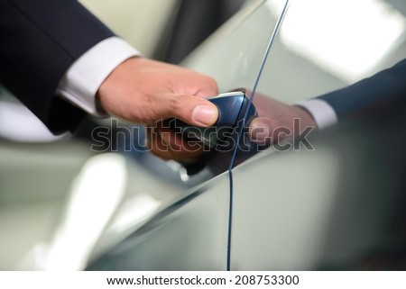 Opening car. Close-up of man in formalwear opening a car door