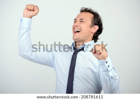 Successful businessman. Happy young man in shirt and tie gesturing while standing against grey background