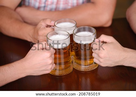 Close-up of young gay men to hold glasses of beer in a beer pub
