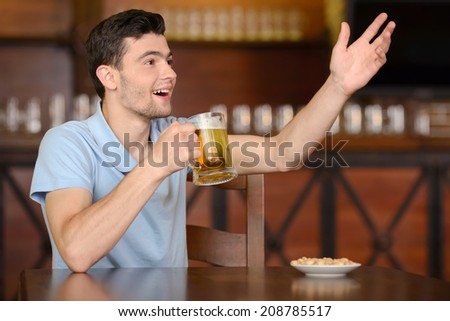 Portrait of cheerful men drinking beer at the bar and appeal to the waiter