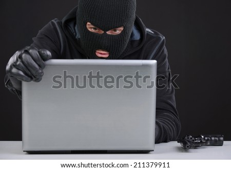 Computer hacking. Close-up of frustrated criminal using computer