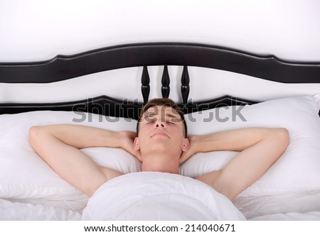 Young, handsome man sleeping in a bed in her bedroom