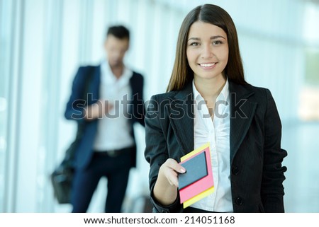 Attractive business woman handing over air ticket at airport check in counter