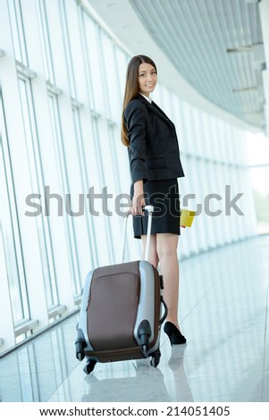 Hurry tickets. Young woman pulling luggage at the airport